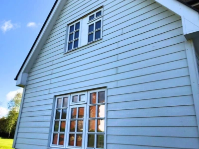 A close-up view of the same exterior cladding after cleaning. The cladding is now spotless, with no visible dirt, grime, or mildew. The surface appears bright and well-maintained, showcasing a significant improvement from its previous state.